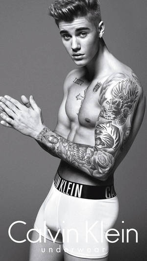 一位有紋身的男子穿著Calvin Klein內衣為時尚照片擺姿勢。