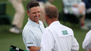 兩名微笑的高爾夫球手在綠色球場上互動。