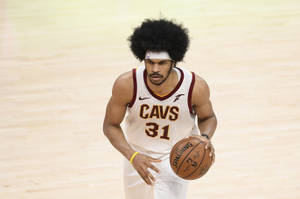 籃球運動員在球場上運球，身穿Cavs球衣
