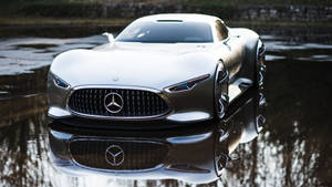 銀色 Mercedes 概念車倒映在濕滑路面的水窪中。