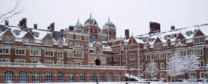 積雪的歷史大學建築，帶有圓頂塔樓和光禿的樹木。