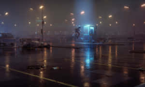 夜晚，一個人站在下雨的城市停車場中，靠近一個發光的電話亭。 — 太空人 壁紙