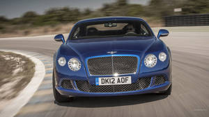 藍色賓利 Continental GT 在賽道上疾馳，帶有動態模糊效果。