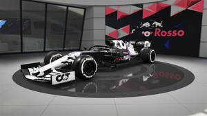 帶有 Red Bull 品牌標誌的黑白一級方程式賽車在現代展廳中展示。 — 電腦 GIF 壁紙