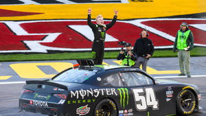NASCAR車手在賽道上於其賽車上慶祝勝利。
