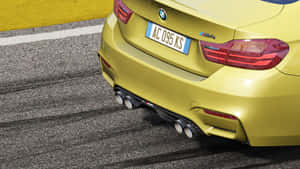 黃色BMW M4賽車後部，排氣管在賽道瀝青上 — 7680x4320 壁紙
