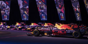 Red Bull F1 賽車在舞台上展示，背景有冠軍旗幟。