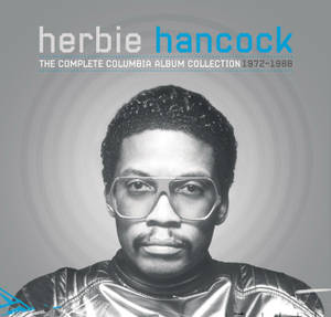 Herbie Hancock 的黑白肖像，戴著大眼鏡和閃亮外套。