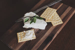 奶油芝士配新鮮香草和餅乾放在木板上。