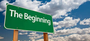 多雲藍天下寫著「The Beginning」的綠色路牌 — 雲朵 壁紙
