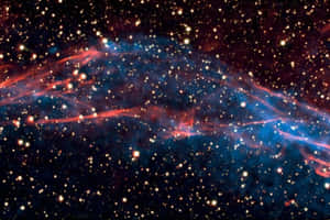 在深空中無數恆星之間發光的鮮豔紅色和藍色宇宙星雲。 — 太空 壁紙