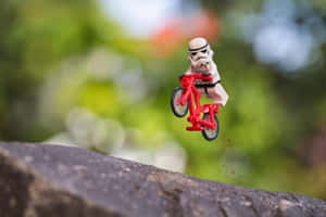 LEGO白兵在半空中騎著紅色單車越過石頭邊緣。