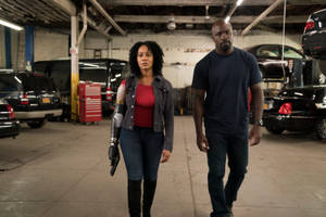 兩個人穿過一個有汽車和工具的汽車修理廠。 — Netflix GIF 壁紙