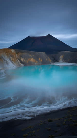 綠松色火山湖在暮色天空下映照黑暗山脈 — 史詩 壁紙