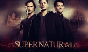 三個身穿深色衣服的男人，站在名為『Supernatural』的鬼屋和墓地前。