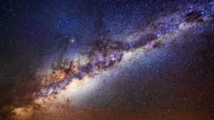 銀河系在繁星點點的夜空中散發著紫色和橙色的星雲光芒。 — 可愛星系 壁紙