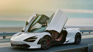 日落時分，白色McLaren跑車在海岸公路上打開鷗翼門。 — 汽車 壁紙