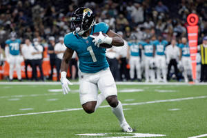 身穿青色球衣的美式足球員在球場上帶球奔跑。 — NFL 美式足球 GIF 壁紙