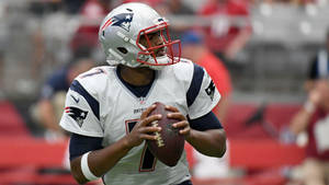 穿著愛國者隊制服的NFL四分衛在比賽中持球。