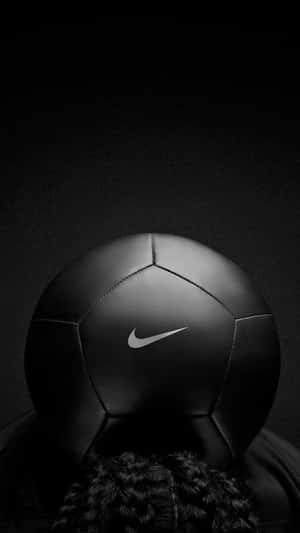 黑色 Nike 足球放在辮子上，背景深色。