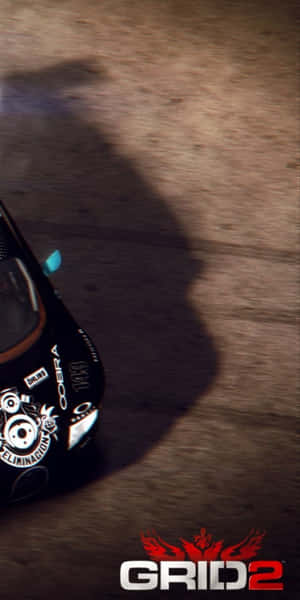 黑色賽車在泥地賽道上奔馳，帶有長影和 'GRID 2' 標誌。 — 汽車 壁紙