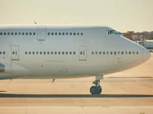 一架白色商用飛機在明亮陽光下停泊在機場停機坪上。 — 飛機 壁紙