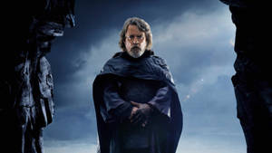Luke Skywalker 身穿深色斗篷站在風暴天空下的岩石縫中