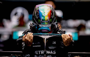 戴著彩色頭盔的F1車手在維修站期間抓住駕駛艙。