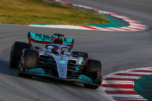 Mercedes F1賽車在日落時分的賽道上奔馳。