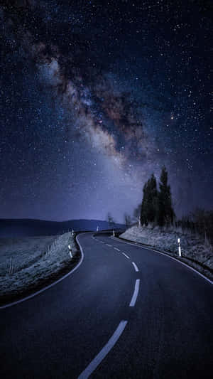 在星空下的一條黑暗蜿蜒道路，銀河可見。