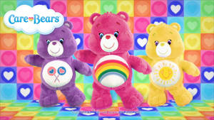 三個Care Bears毛絨玩具站在色彩繽紛的心形圖案地板上。