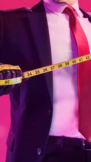 穿西裝的男人在粉紅色背景前拿著軟尺 — 殺手 壁紙