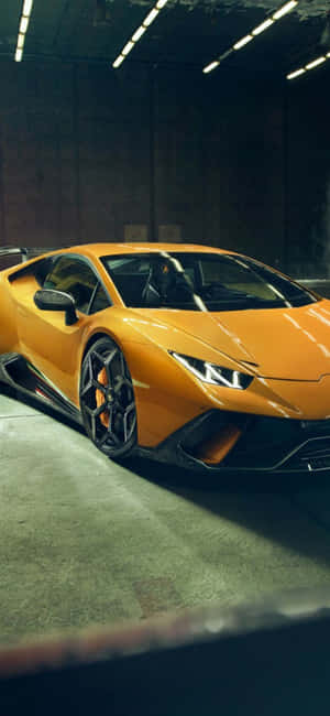 螢光燈下的混凝土車庫中的橙色林寶堅尼 Huracán。