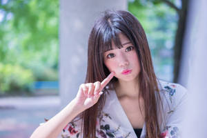 年輕女性身穿花卉和服，在陽光明媚的日子裡於戶外觸碰臉頰。