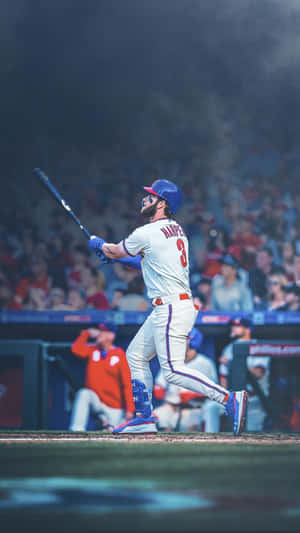 Bryce Harper 在夜間比賽中揮動棒球棒，觀眾在觀看。 — 棒球 壁紙