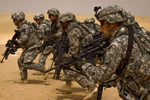 身穿沙漠迷彩的士兵以戰鬥隊形手持步槍前進。 — 軍事動圖 壁紙