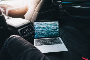 在陽光明媚的駕駛中，汽車座椅上的海洋桌面筆記型電腦。 — 美學筆電 壁紙