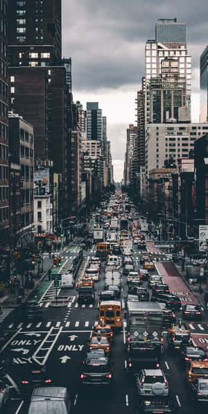 繁忙的城市街道，在多雲的天空下，充滿汽車和高樓大廈。