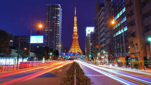 夜晚亮燈的東京鐵塔，伴隨移動汽車的光軌。 — 日本 壁紙