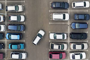 停車場的鳥瞰圖，許多汽車排列成行，一輛白色汽車斜停。 — 汽車 壁紙