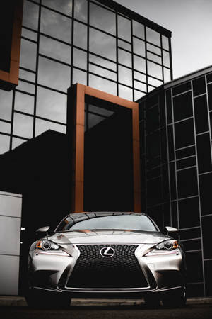 銀色 Lexus 汽車停泊在現代玻璃建築前。