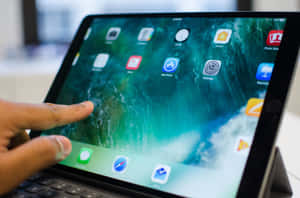 手與顯示海洋牆紙和應用程式圖標的iPad互動。