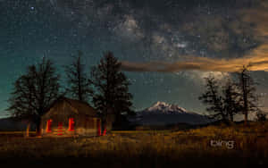一間舒適的小屋，溫暖的紅光，在星空下，遠處有雪山。