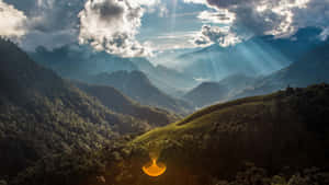 陽光穿透雲層，照耀在鬱鬱蔥蔥的山谷上。