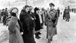穿著冬季外套的女性在雪地營地中向一名制服軍官敬禮。 — 戰爭 壁紙