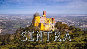 山上的佩納宮殿，綠色樹木和下方山谷上方有文字 SINTRA。