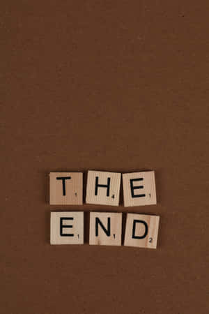 木製 Scrabble 字塊在棕色背景上拼出 the end