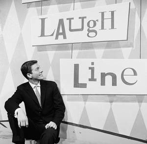 西裝男士在 'LAUGH Line' 標誌旁微笑的黑白工作室照片。