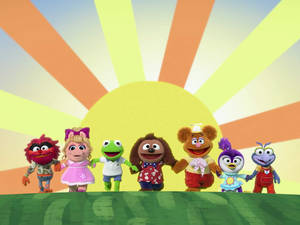 七個Muppet角色在太陽光下草地上手牽手。 — 布公仔大電影 GIF 壁紙