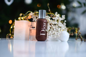 Dior 香水瓶、蠟燭和滿天星在節日散景燈光中。
